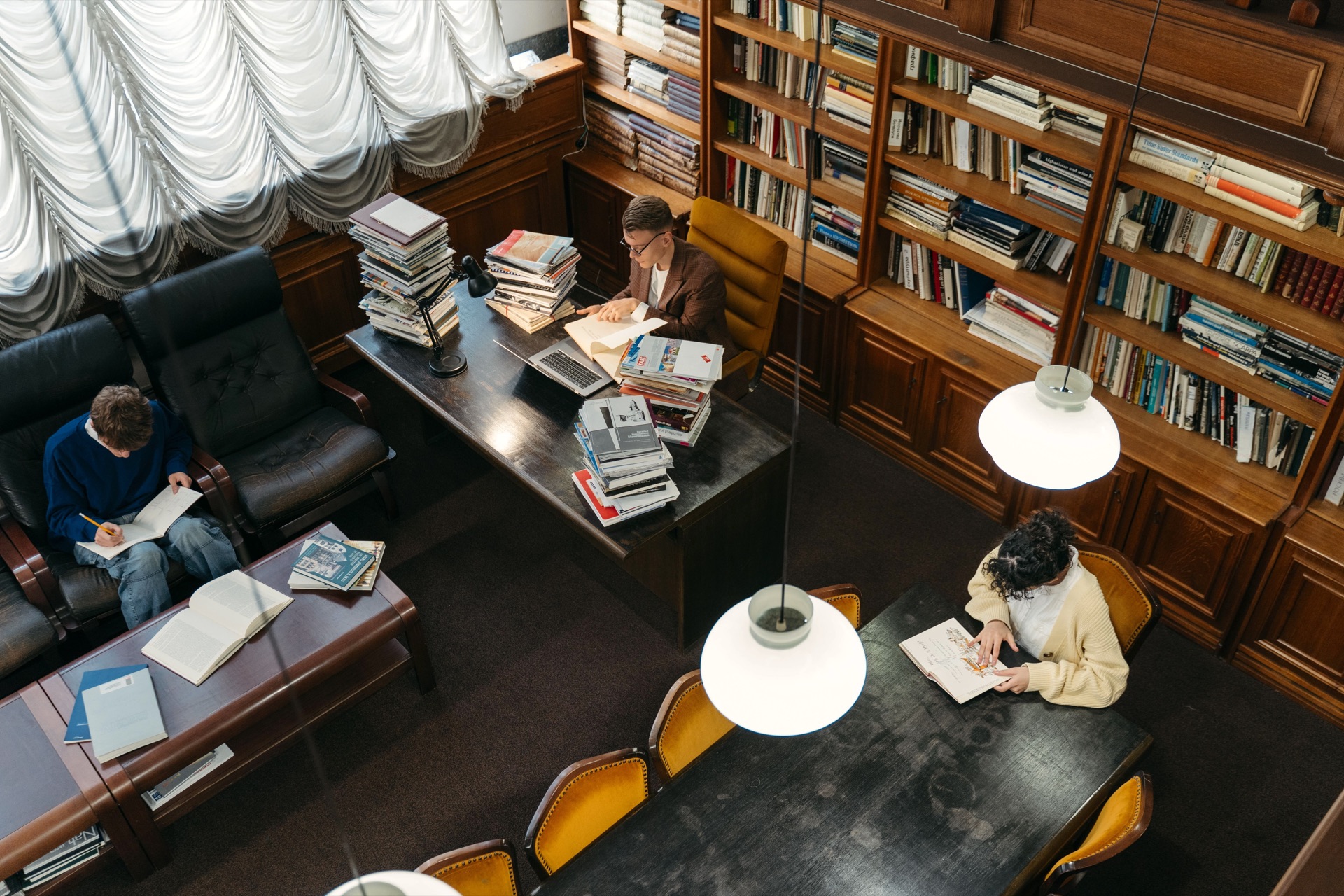 Lesende und arbeitende Menschen in einer Bibliothek